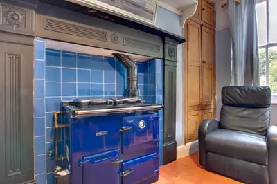 a blue tiled kitchen with a stove and a chair at 6 Bed in Dolgellau oc-wah675 in Arthog