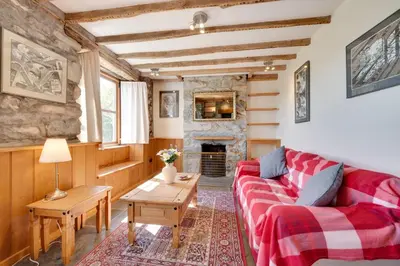 a living room with a red couch and a fireplace at 3 Bed in Dolgellau oc-wah570 in Llanfachreth