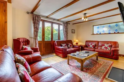 a living room with red leather furniture and a table at 4 Bed in Caersws oc-waa321 in Trefeglwys