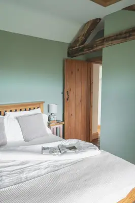 a bedroom with a white bed and a blue wall at 3 Bed in Llangadfan oc-wae284 in Llangadfan