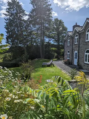 a house with a bench in front of a yard at 3 Bed in Llangadfan oc-wae284 in Llangadfan
