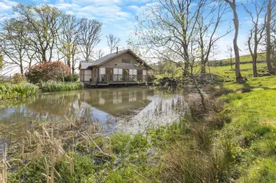 a house with a pond in front of it at 2 Bed in Caersws oc-waa345 in Trefeglwys