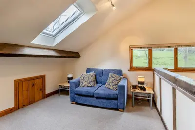 a living room with a blue chair and a skylight at 2 Bed in Caersws oc-waa345 in Trefeglwys