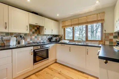 a kitchen with white cabinets and black counter tops at 2 Bed in Caersws oc-waa345 in Trefeglwys