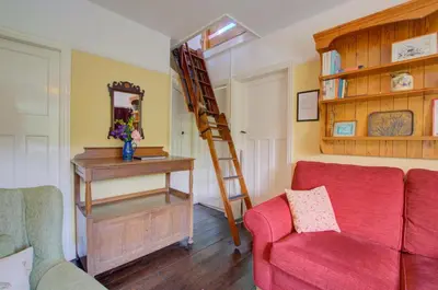 a living room with a red couch and a ladder at 3 Bed in Llangollen oc-waf216 in Glyn-Ceiriog