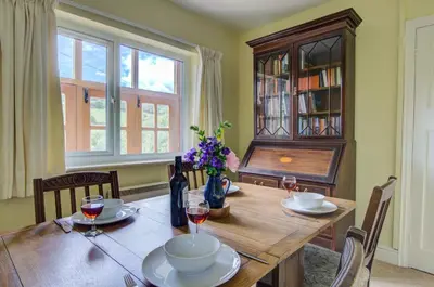 a dining room with a wooden table with glasses of wine at 3 Bed in Llangollen oc-waf216 in Glyn-Ceiriog