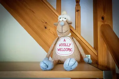a stuffed animal is sitting on a stair case at Berries Coach House in Church Stretton