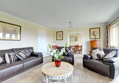 a living room with leather couches and a table at Tredegar in Dyffryn