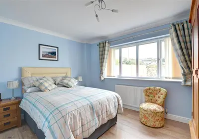 a bedroom with a bed and a chair and a window at Tredegar in Dyffryn