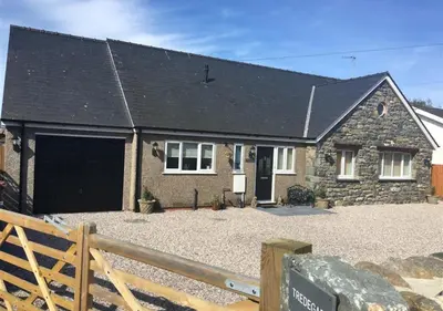 a stone house with a black roof at Tredegar in Dyffryn