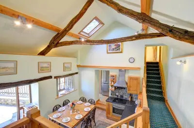 a living room with a table and a staircase at 4 Bed in Dolgellau oc-wah568 in Llanfachreth