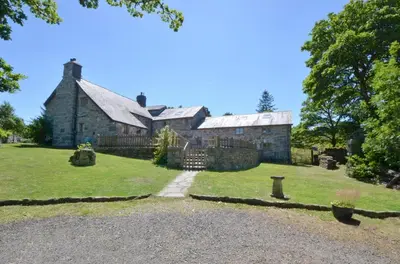 an old stone house with a grassy yard at 4 Bed in Dolgellau oc-wah568 in Llanfachreth