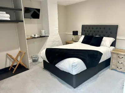 a bedroom with a large bed with a black headboard at The Beacons Guest House in Brecon