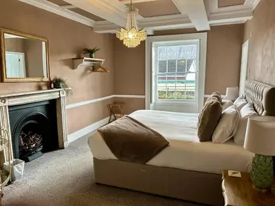 a bedroom with a bed with a fireplace and a mirror at The Beacons Guest House in Brecon