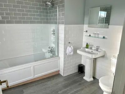 a bathroom with a tub and a sink and a toilet at The Beacons Guest House in Brecon