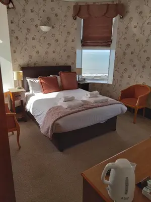 a bedroom with a large bed and a window at Tyr Graig Castle in Barmouth