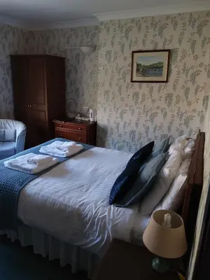 a bedroom with a large bed with blue pillows at Tyr Graig Castle in Barmouth