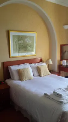 a bedroom with a large bed with white pillows at Tyr Graig Castle in Barmouth