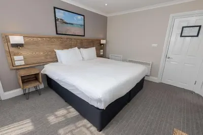 a bedroom with a large bed with a wooden headboard at Dovey Inn in Aberdyfi