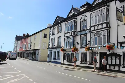 a group of people standing outside of a building on a street at Dovey Inn in Aberdyfi