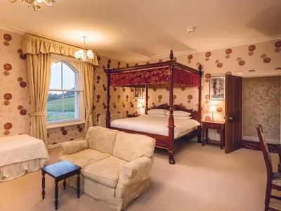 a bedroom with a four poster bed and a couch at The Forest Country House B&B in Newtown