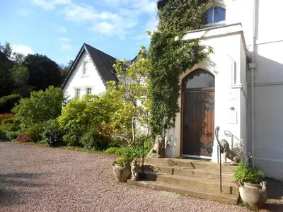 a white house with potted plants in front of it at The Forest Country House B&B in Newtown