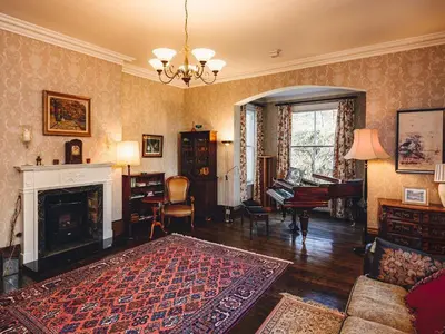 a living room with a fireplace and a piano at The Forest Country House B&B in Newtown