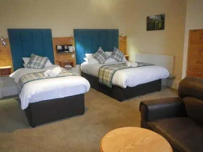 a hotel room with two beds and a couch at Burton Hotel in Kington