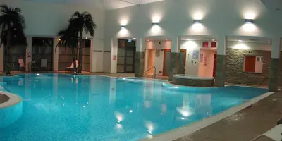 a large blue swimming pool in a building at Burton Hotel in Kington