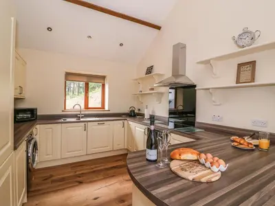 a kitchen with a counter with a sink and a stove at Pentre Fach in Llanddewi Ystradenny