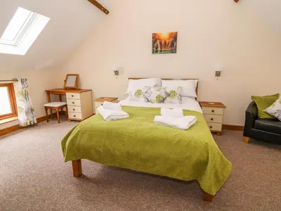 a bedroom with a bed with two towels on it at Pentre Fawr in Llanddewi Ystradenny
