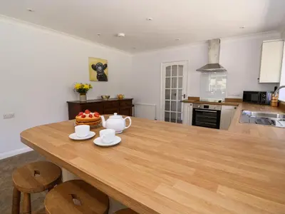 a kitchen with a wooden table with a cake on it at Pen Y Maes in Builth Wells