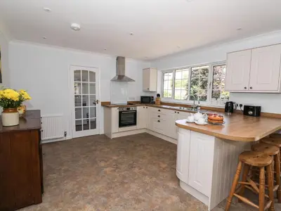 a kitchen with white cabinets and a wooden counter top at Pen Y Maes in Builth Wells