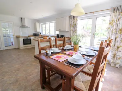 a kitchen and dining room with a wooden table and chairs at Pen Y Maes in Builth Wells