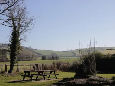 a picnic table in the middle of a field at Bicton Cottage in Acton