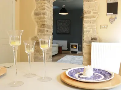 a table with two wine glasses and a plate of cheese at Woodpecker Cottage in Ludlow