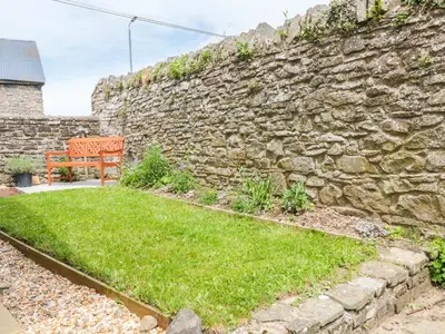 a bench sitting next to a stone wall at The Courtyard in Kington