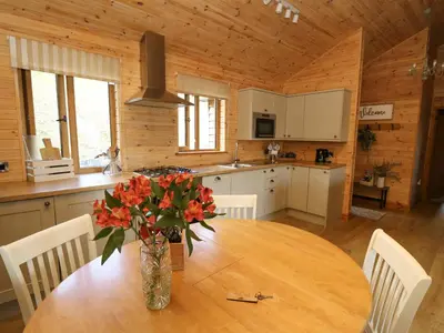 a kitchen with a table with a vase of flowers on it at The Firs in Llanidloes