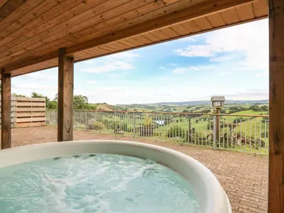 a jacuzzi tub on a patio with a view at The Firs in Llanidloes