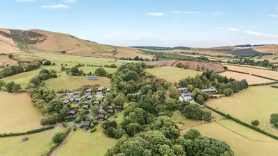 an aerial view of a farm with trees and houses at Glanyrafon in Rhayader