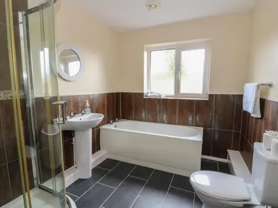 a bathroom with a tub and a sink and a toilet at Glanyrafon Bungalow in Rhayader