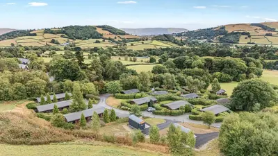 an aerial view of a farm with trees and buildings at Glanyrafon Bungalow in Rhayader