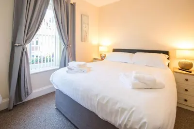 a bedroom with a bed with white sheets and a window at The Royal Oak Pub in Lampeter