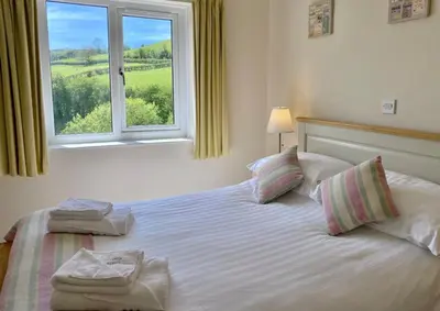 a bedroom with a bed with two towels on it at Llety Ceiro Guesthouse in Aberystwyth