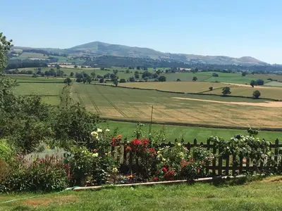 a garden with flowers and a fence in a field at The View in Welshpool