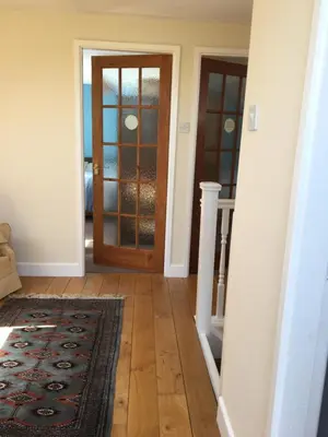 a hallway with a wooden door and a rug at The View in Welshpool