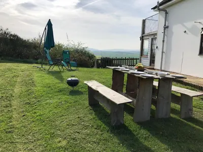 a wooden picnic table in the grass next to a building at The View in Welshpool
