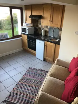 a kitchen with a couch and a stove top oven at The View in Welshpool