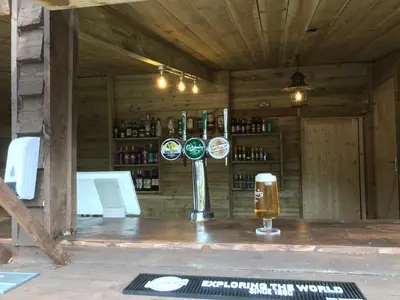 a bar with a glass of beer on a counter at Grapes Hotel, Bar & Restaurant Snowdonia Nr Zip World in Blaenau-Ffestiniog