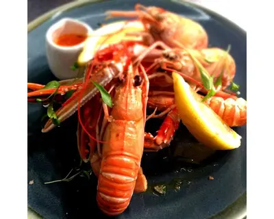 a plate of seafood with a lobster and a lemon at Seabreeze Restaurant With Rooms in Aberdyfi